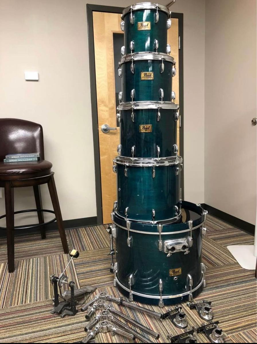 Pearl Prestige Studio Select kit in teal before, shells stacked in a room